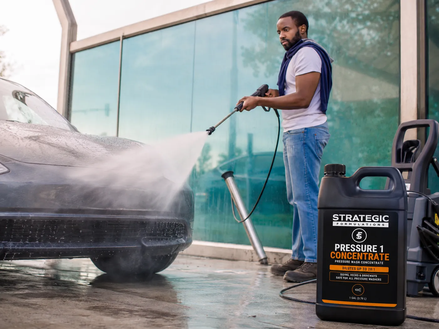 Pressure washing a vehicle outside a commercial building, PRESSURE 1 CONCENTRATE beside the machine